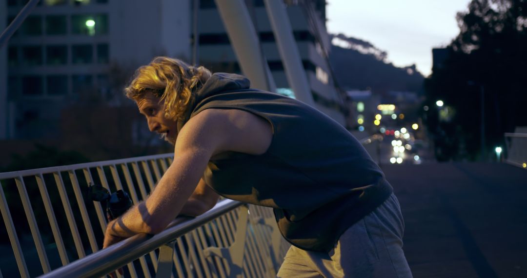 Exhausted Athlete Resting on City Bridge at Dusk - Free Images, Stock Photos and Pictures on Pikwizard.com