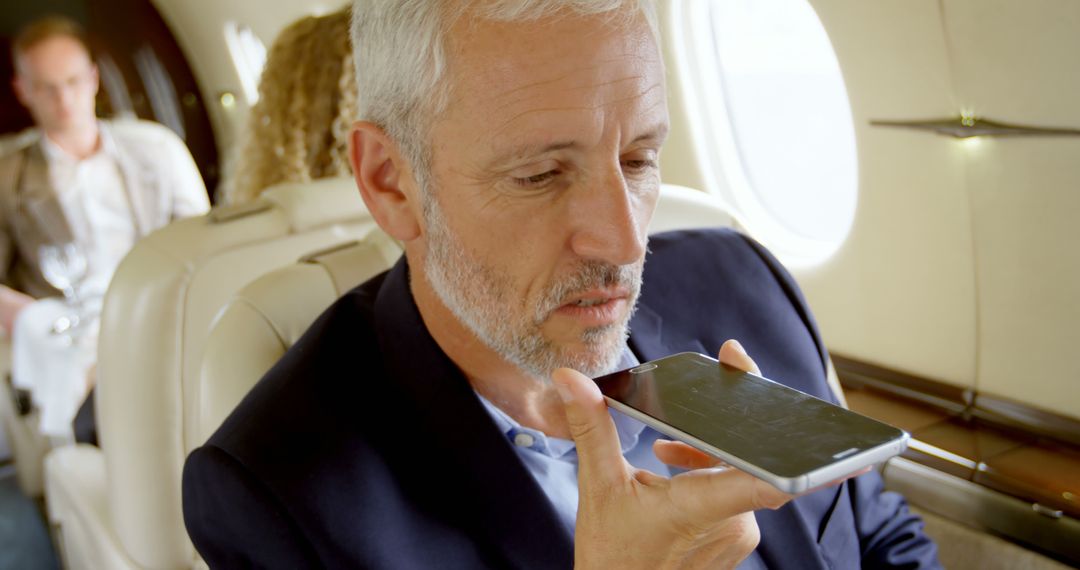 Businessman Communicating via Smartphone on Private Jet