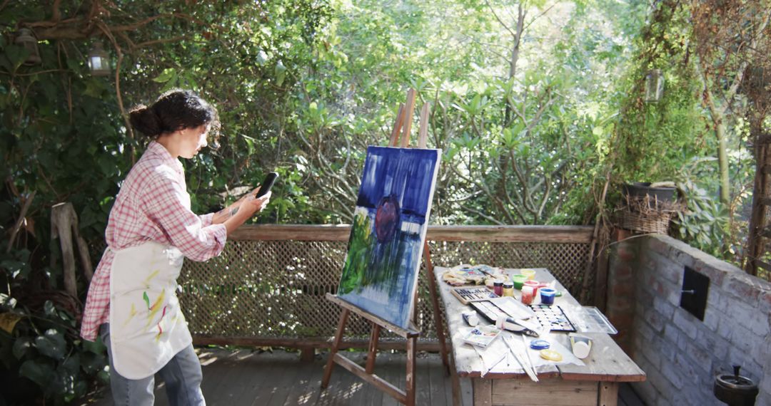 Female Artist Taking Photo of Painting in Garden Studio - Free Images, Stock Photos and Pictures on Pikwizard.com