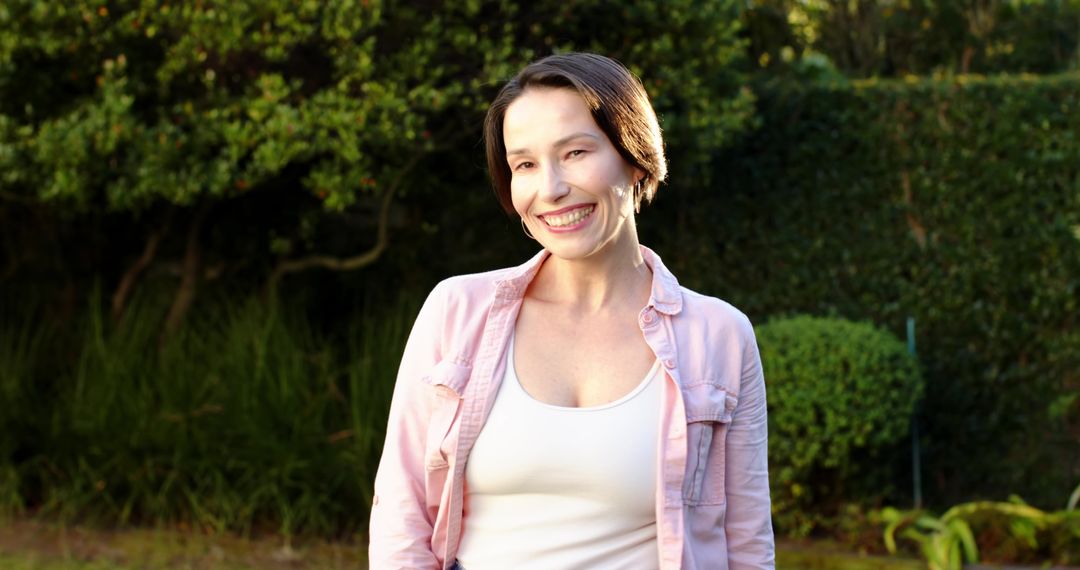 Smiling Woman Enjoying Sunshine in Vibrant Garden