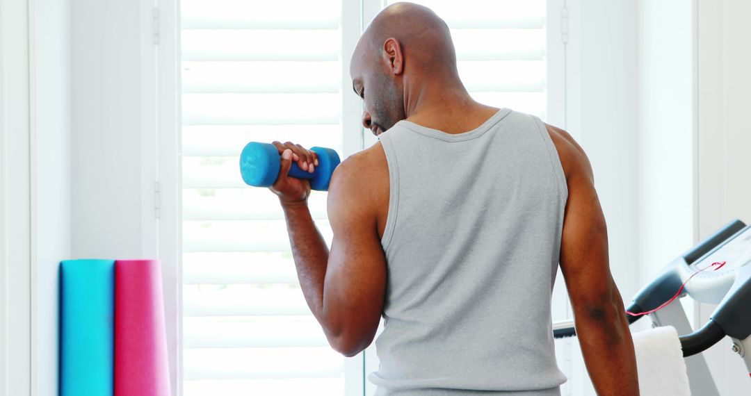 Man Exercising with Dumbbell in Home Gym - Free Images, Stock Photos and Pictures on Pikwizard.com