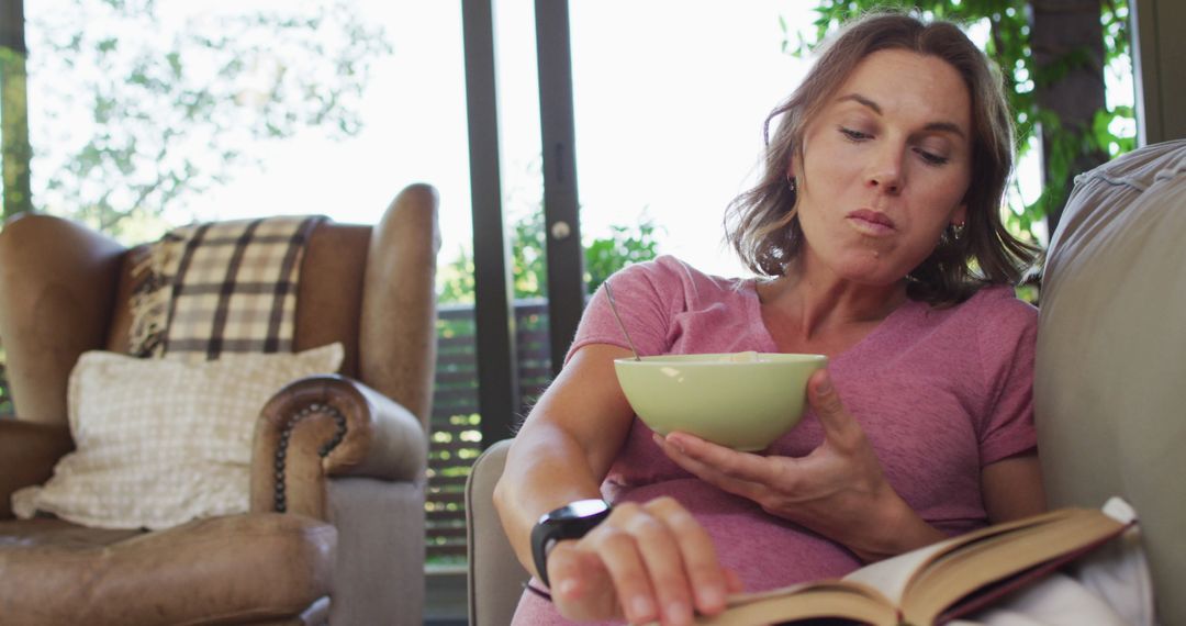 Pregnant Woman Enjoys Reading and Snacking at Home