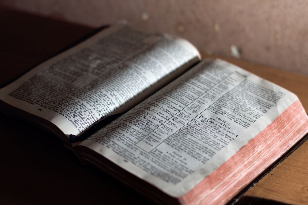 Open bible book on wooden table with soft ambient light