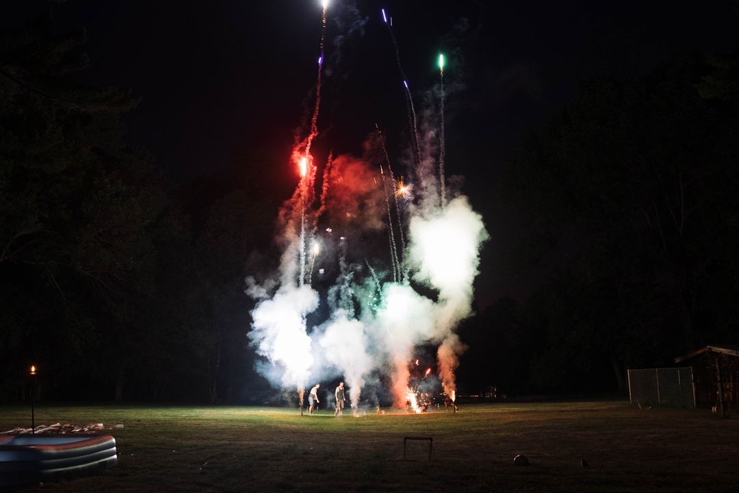 Colorful Fireworks Exploding in Night Sky over Field