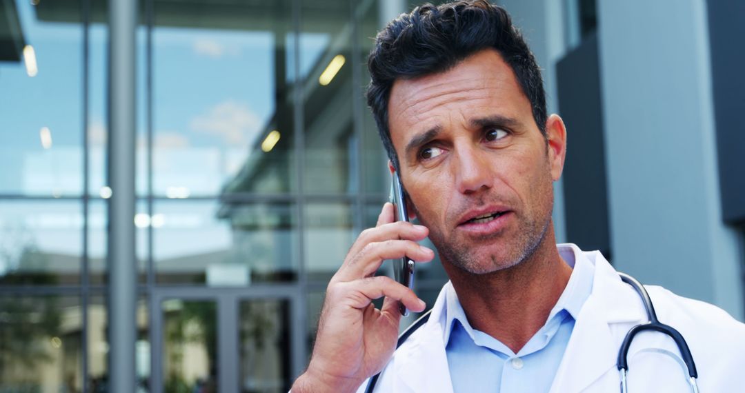 Male Doctor on Phone Call Outside Modern Hospital - Free Images, Stock Photos and Pictures on Pikwizard.com