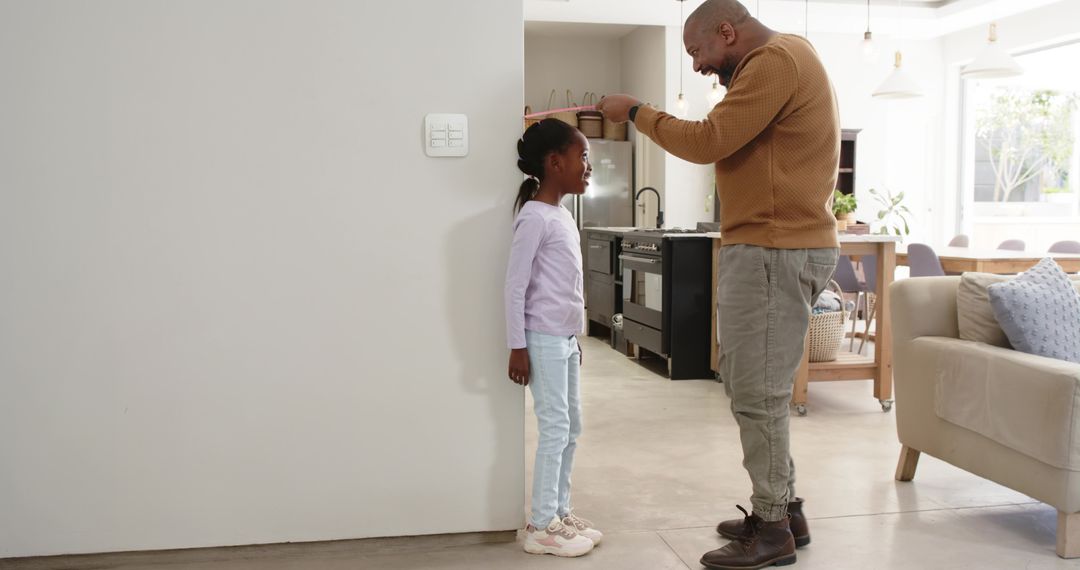 Father and Daughter Tracking Height at Home in Modern Kitchen