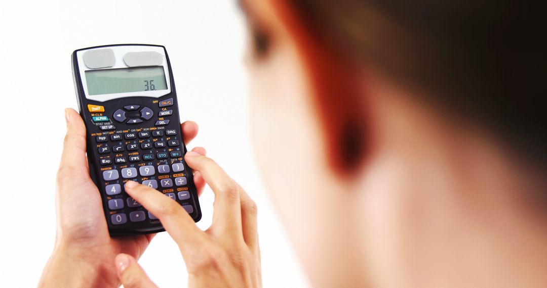 A young Asian person is focused on solving a problem using a scientific calculator, with copy space - Free Images, Stock Photos and Pictures on Pikwizard.com