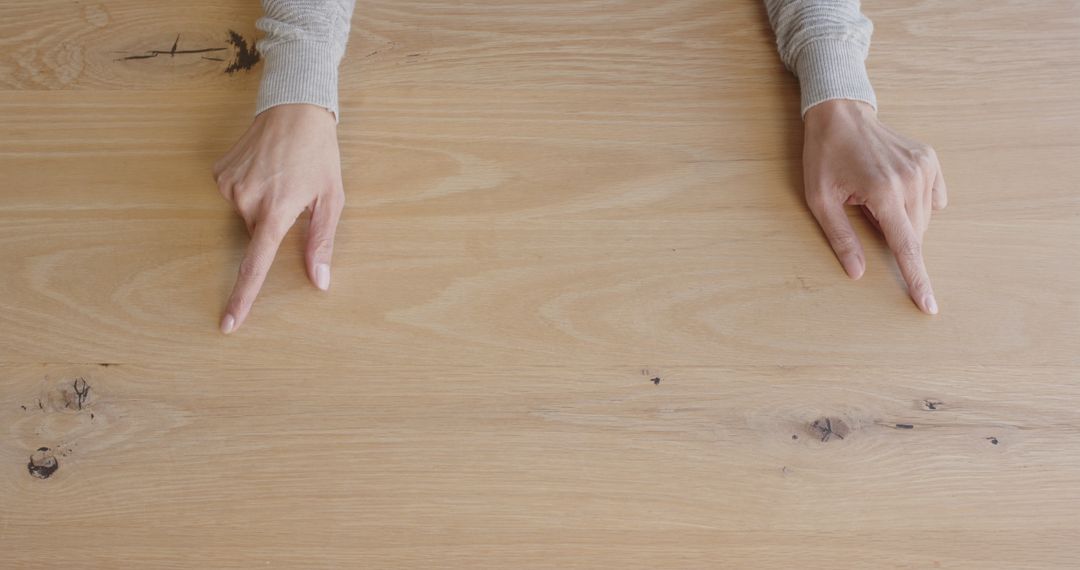 Hands Discussing Ideas on Wooden Desk