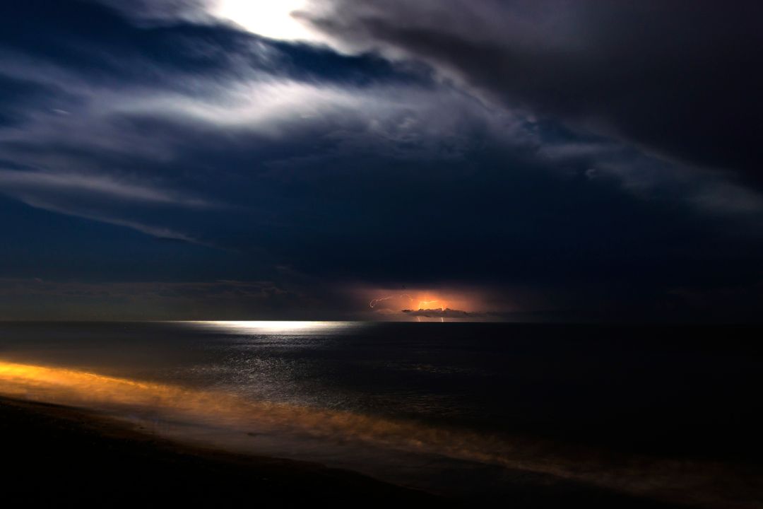 Dramatic Coastal Night Sky with Lightning Over Calm Ocean - Free Images, Stock Photos and Pictures on Pikwizard.com