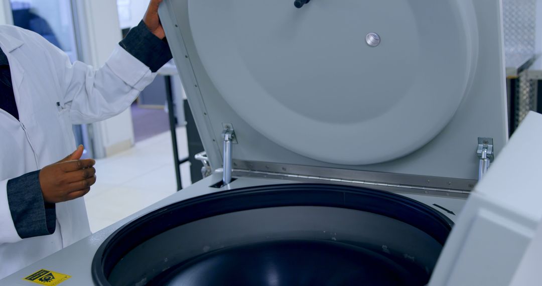 Scientist operating high-speed laboratory centrifuge in lab - Free Images, Stock Photos and Pictures on Pikwizard.com