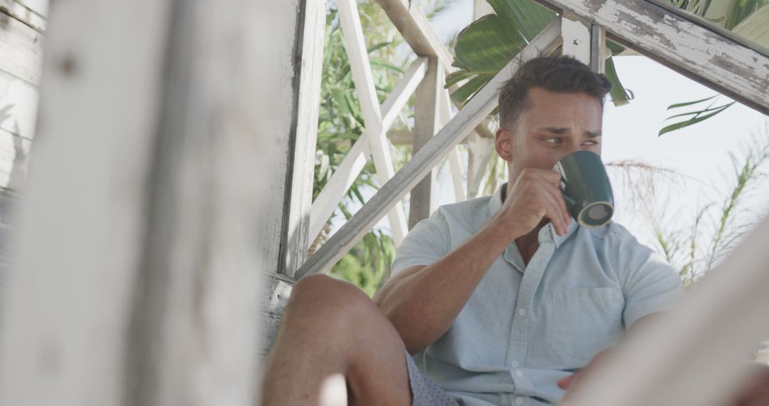 Man Enjoying Coffee on Tropical Veranda - Free Images, Stock Photos and Pictures on Pikwizard.com