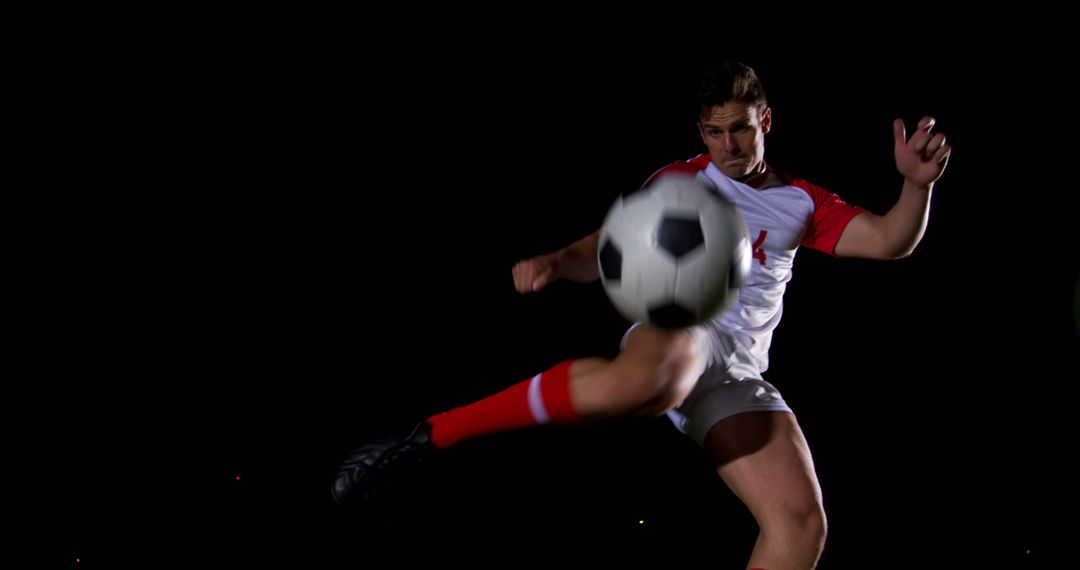 Soccer Player Kicking Ball During Nighttime Match - Free Images, Stock Photos and Pictures on Pikwizard.com