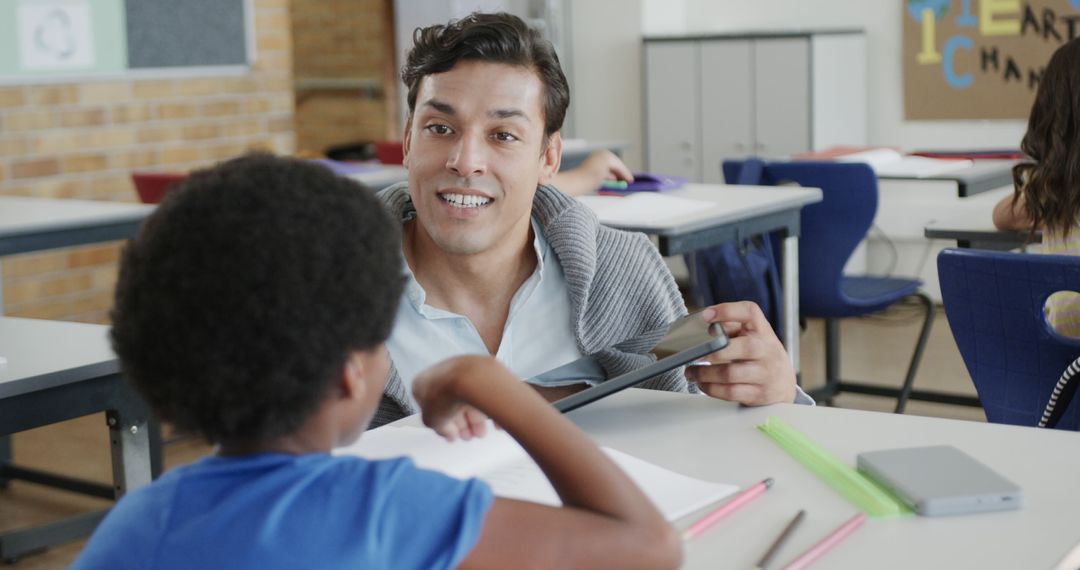 Male Teacher Helping Young Student in Classroom - Free Images, Stock Photos and Pictures on Pikwizard.com