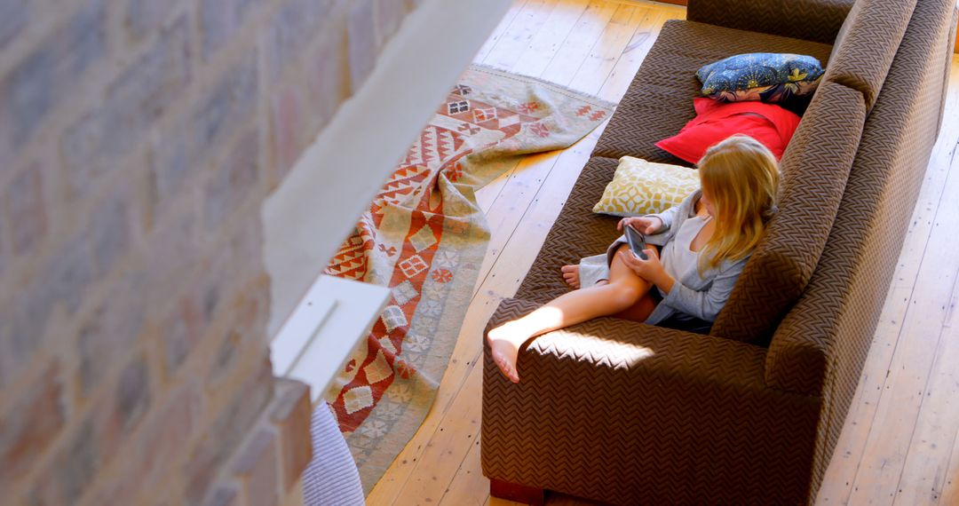 Girl Relaxing on Sofa Using Tablet in Cozy Living Room - Free Images, Stock Photos and Pictures on Pikwizard.com