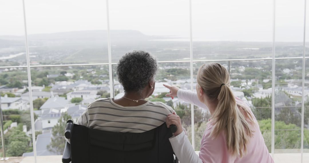 Woman Caring for Elderly Individual in Wheelchair, Enjoying Scenic View - Free Images, Stock Photos and Pictures on Pikwizard.com