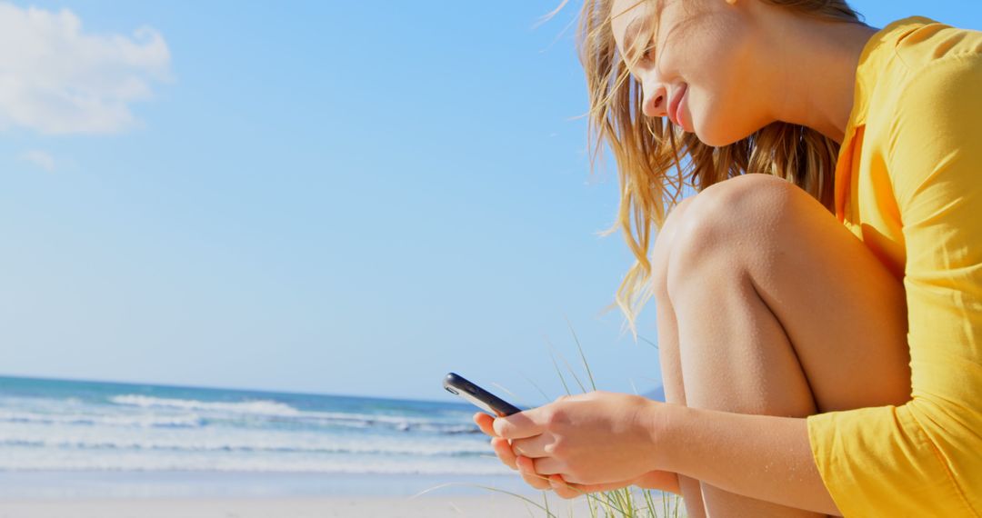 Young Woman Using Smartphone Relaxing on Beach on Sunny Day - Free Images, Stock Photos and Pictures on Pikwizard.com