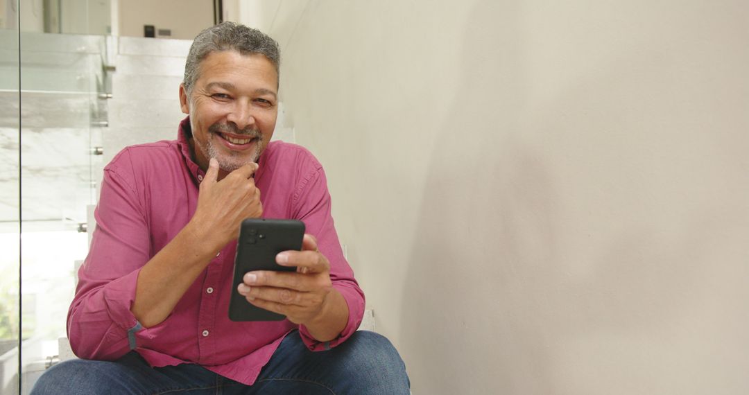 Smiling Man Using Smartphone in Stylish Home Interior