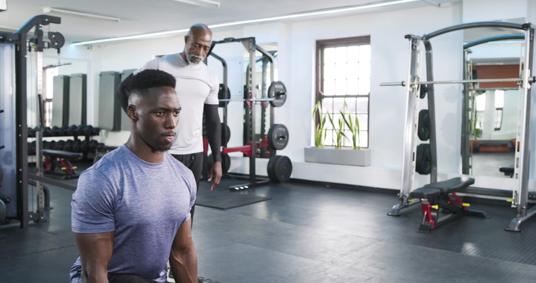 Personal Trainer Coaching Client on Kneeling Lunge Technique in Modern Gym