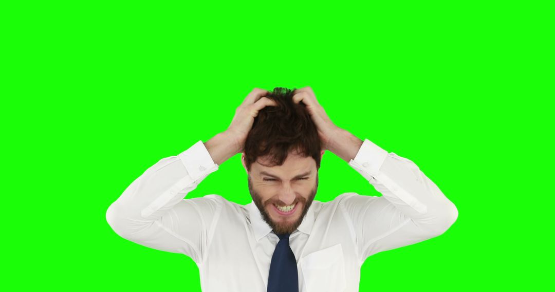A stressed young businessman exhibits signs of anxiety against a green screen with copy space. - Free Images, Stock Photos and Pictures on Pikwizard.com