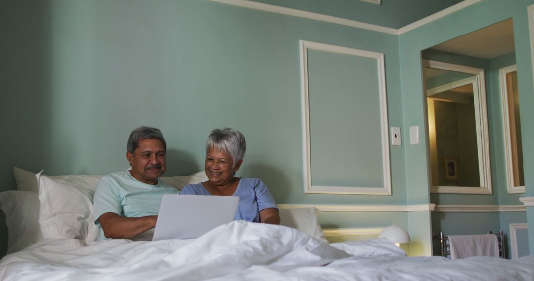 Happy Senior Couple Using Laptop in Cozy Bedroom - Free Images, Stock Photos and Pictures on Pikwizard.com