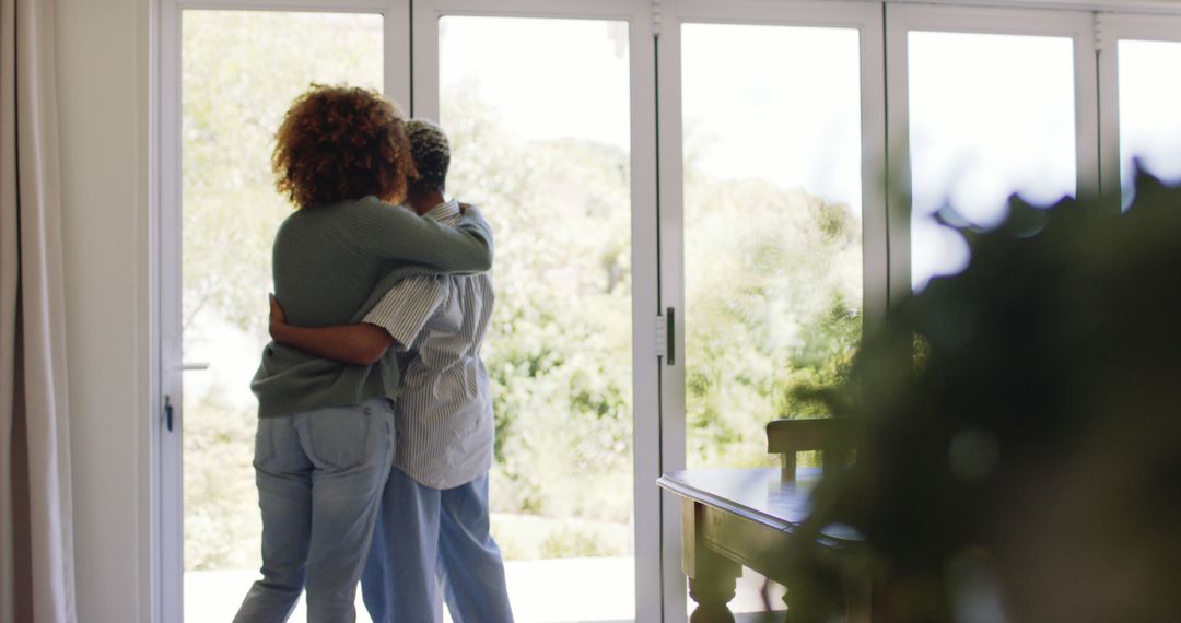 Loving Lesbian Couple Embracing by Sunlit Window at Home