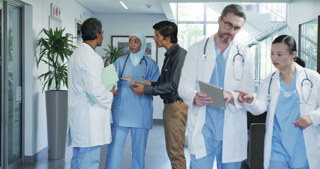 Medical Professionals Collaborating in Hospital Corridor - Free Images, Stock Photos and Pictures on Pikwizard.com