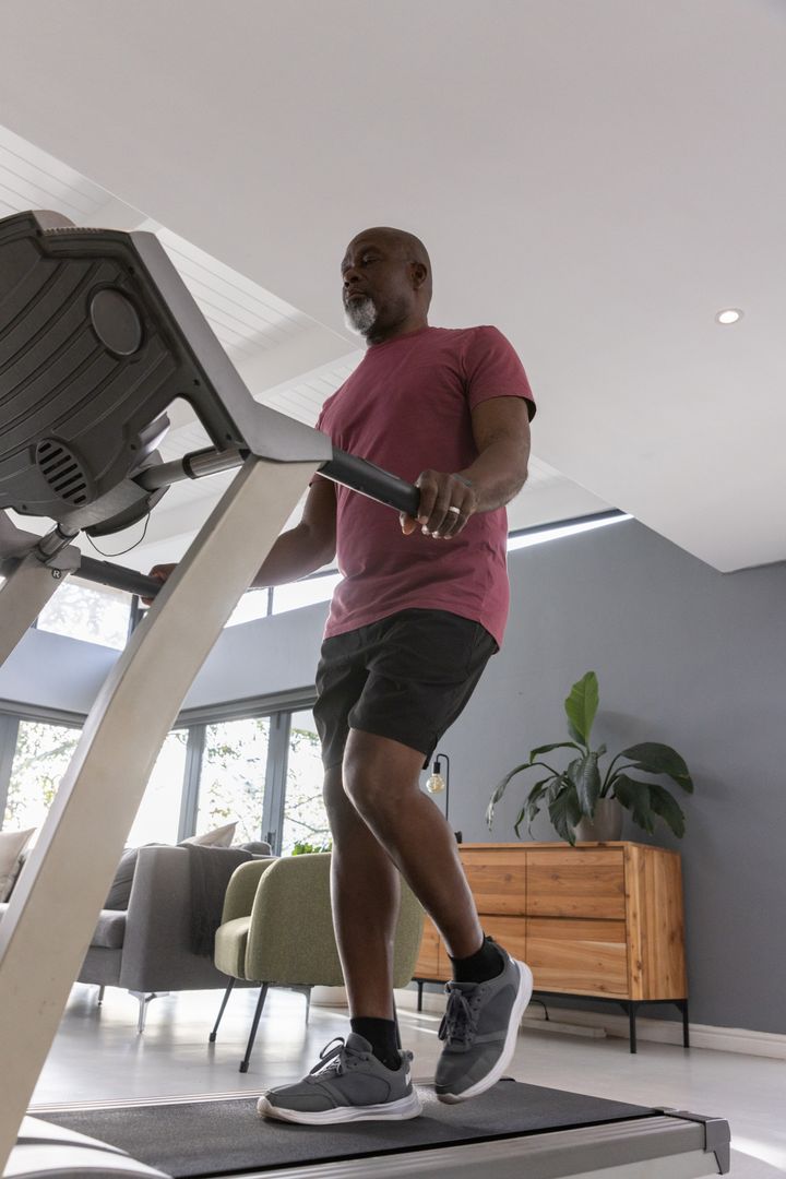 Active Senior Man Running on Treadmill at Home with Modern Decor