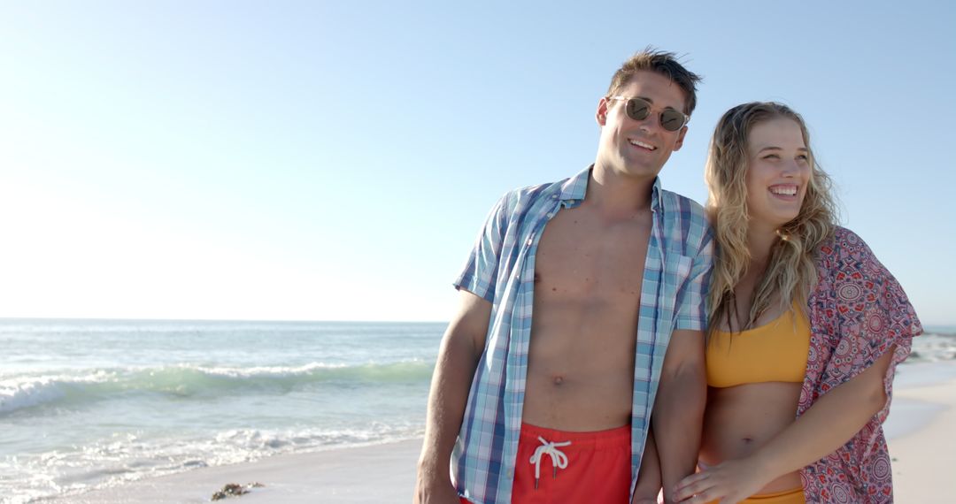 Happy Couple Enjoying Sunny Day Walking on Serene Beach