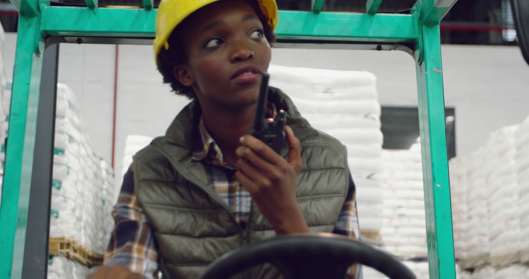 Warehouse Worker Operating Forklift while Communicating on Radio - Free Images, Stock Photos and Pictures on Pikwizard.com