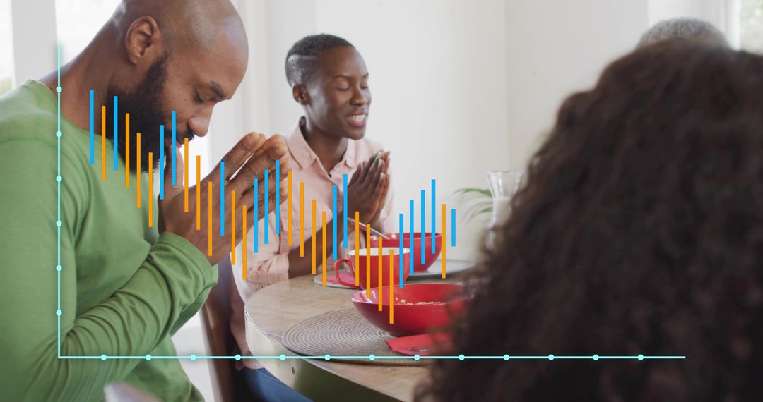 Multigenerational family praying together at dining table with data chart overlay