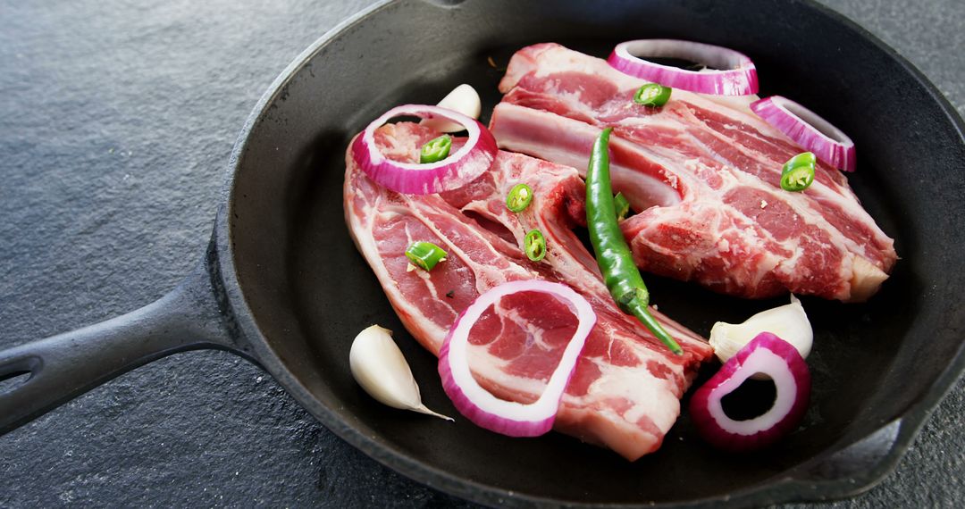 Fresh Raw Pork Ribs with Onions, Peppers, and Garlic in Cast Iron Pan - Free Images, Stock Photos and Pictures on Pikwizard.com