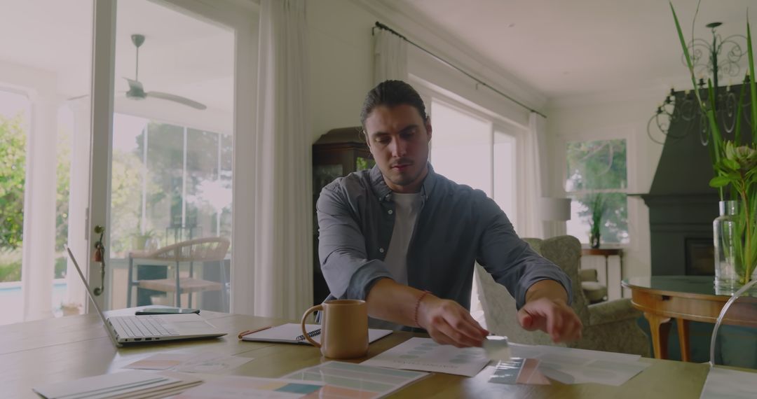 Man Managing Documents and Call in Home Office Setup