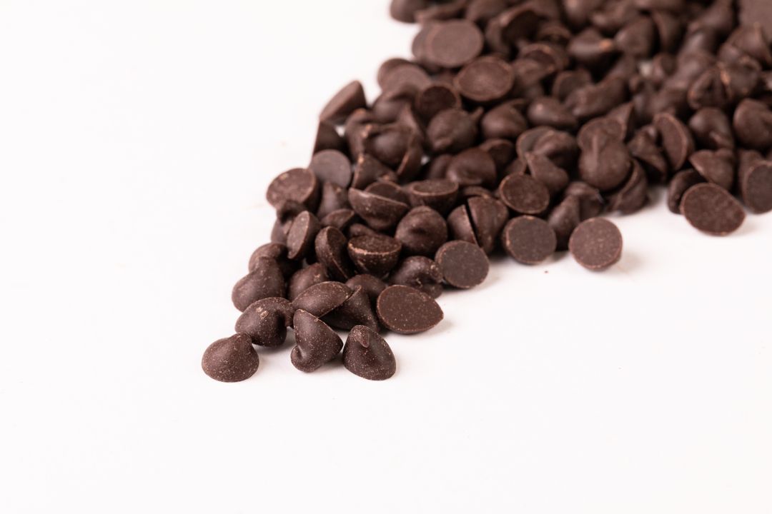 High angle view of fresh chocolate chips on white background - Free Images, Stock Photos and Pictures on Pikwizard.com