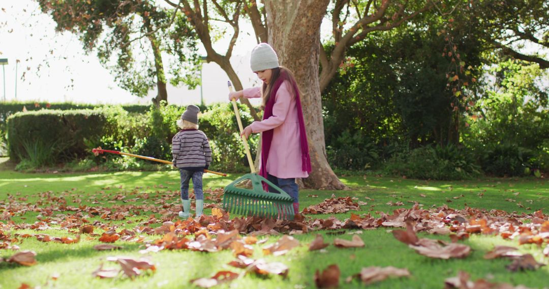 Children Raking Autumn Leaves in Sunny Garden - Free Images, Stock Photos and Pictures on Pikwizard.com