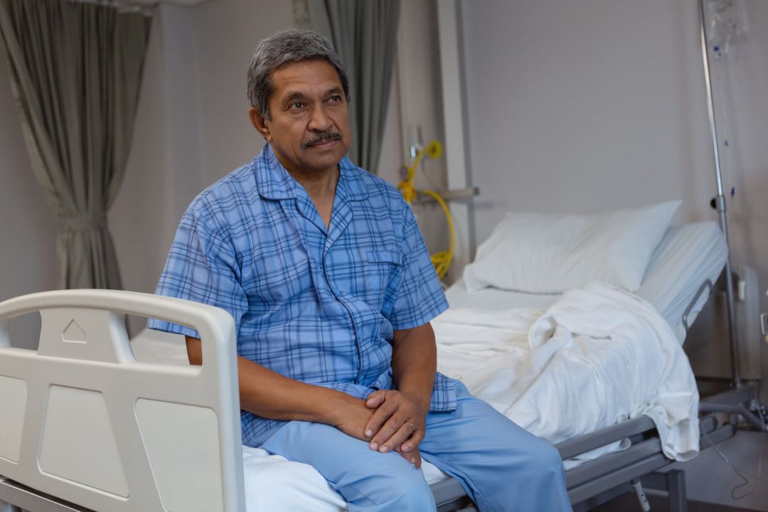 Mature Patient Sitting on Hospital Bed in Ward - Free Images, Stock Photos and Pictures on Pikwizard.com