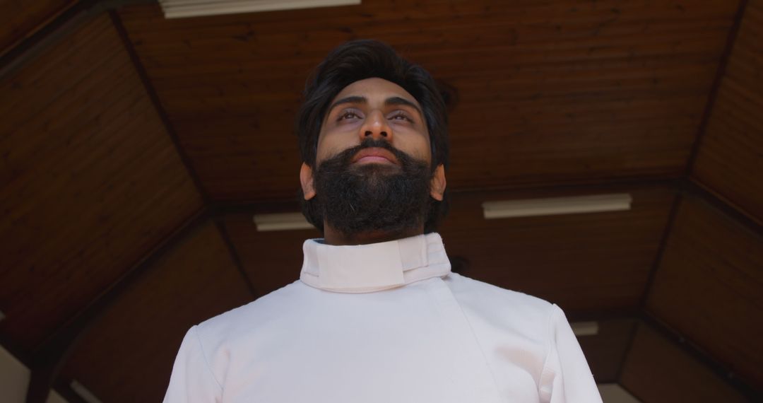 Front View of Bearded Man Wearing White Traditional Attire in Wooden Ceiling Interior - Free Images, Stock Photos and Pictures on Pikwizard.com