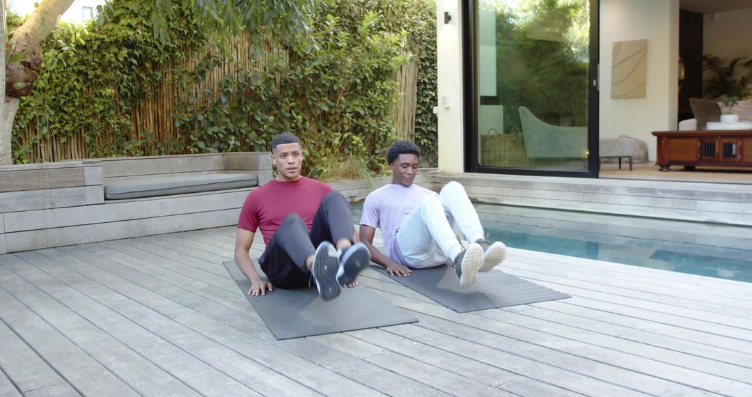 Male Friends Performing Core Exercises by Pool in Leisure Center