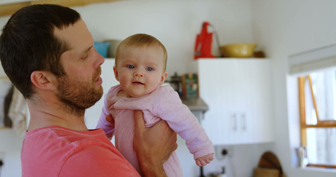 Caring Father Holding Excited Baby in Cozy Home Setting - Free Images, Stock Photos and Pictures on Pikwizard.com