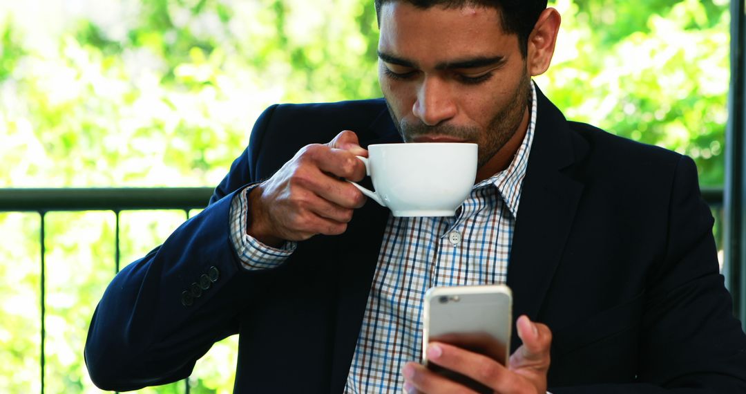 Businessman Drinking Coffee While Checking Smartphone Outdoors - Free Images, Stock Photos and Pictures on Pikwizard.com