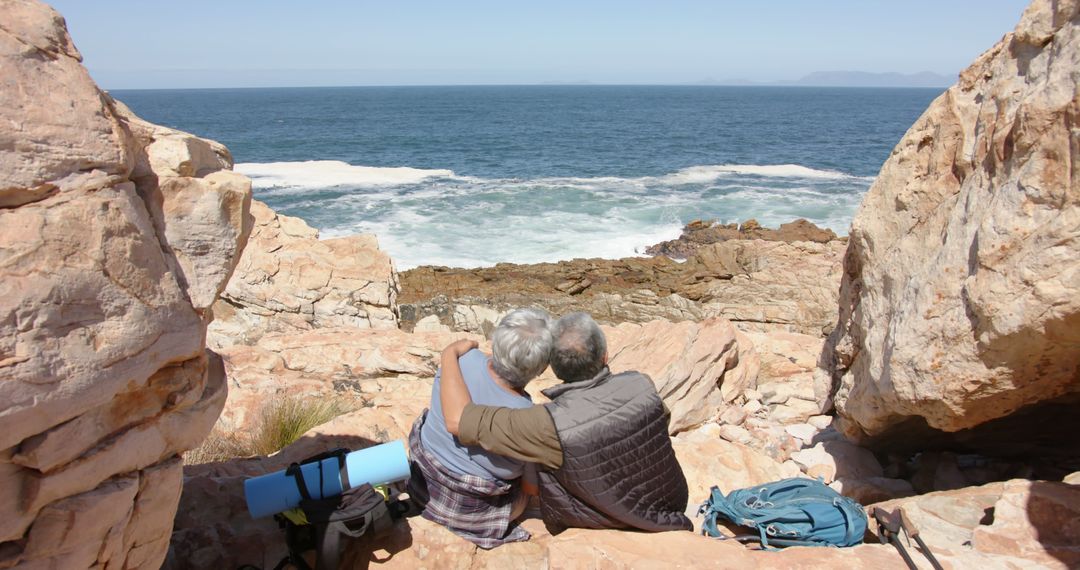 Senior Couple Embracing on Coastal Rocks with Ocean View - Free Images, Stock Photos and Pictures on Pikwizard.com