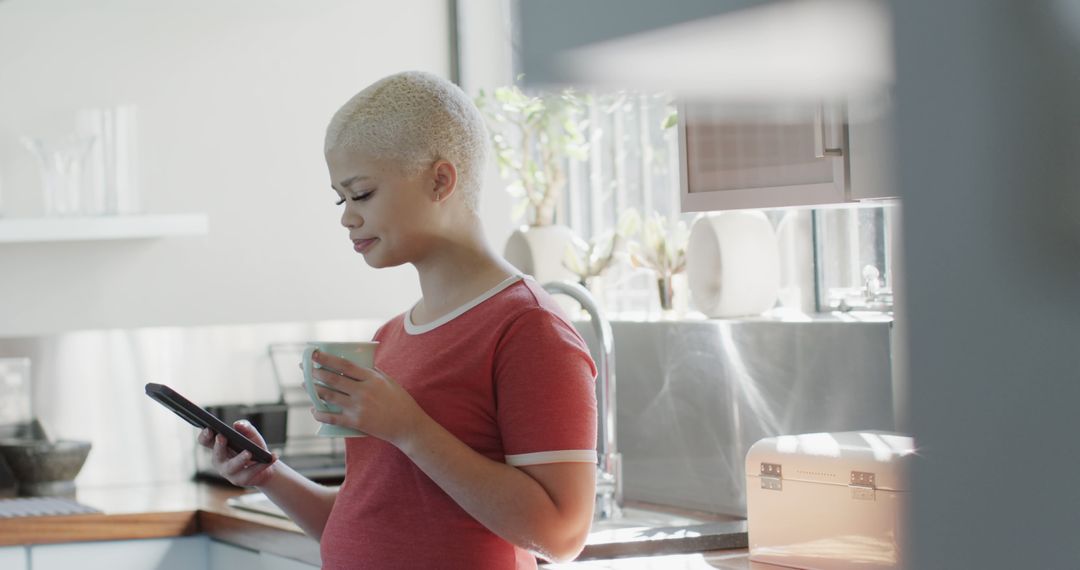 Pregnant Woman Holding Coffee While Using Smartphone in Kitchen - Free Images, Stock Photos and Pictures on Pikwizard.com