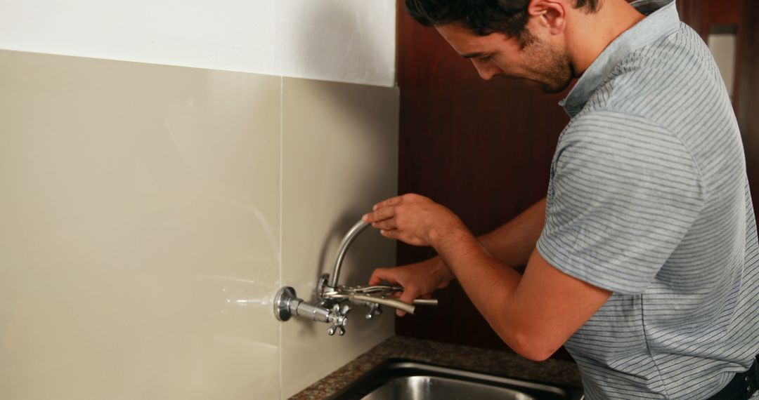 Man Repairing Kitchen Faucet with Tools - Free Images, Stock Photos and Pictures on Pikwizard.com