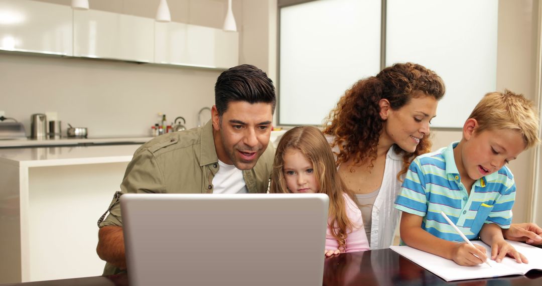 Happy Family Using Laptop and Drawing in Modern Kitchen