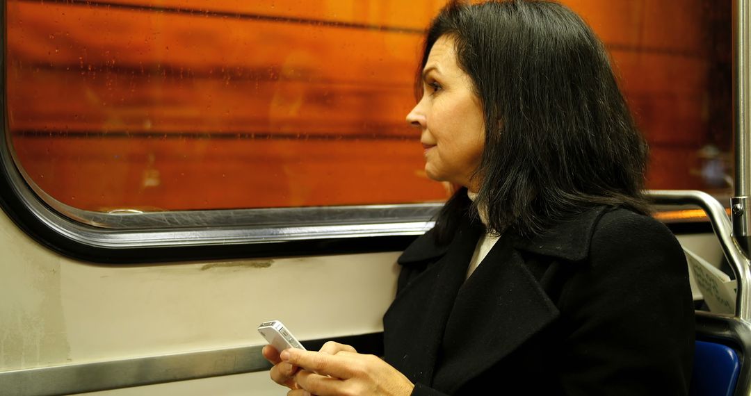 Woman Traveling on Subway Holding Smartphone - Free Images, Stock Photos and Pictures on Pikwizard.com