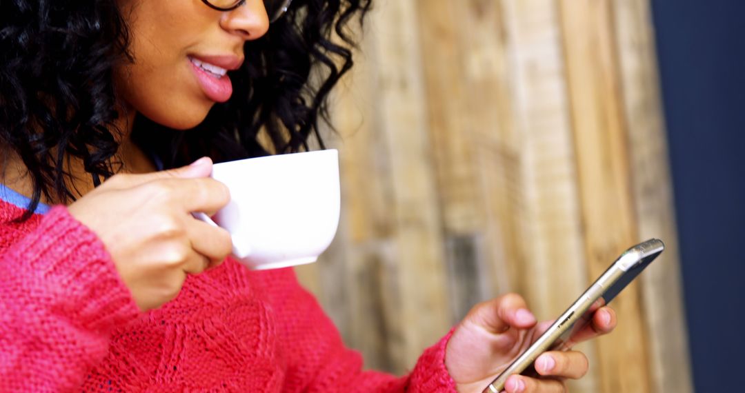 Woman Drinking Coffee While Browsing Smartphone in Cozy Setting - Free Images, Stock Photos and Pictures on Pikwizard.com