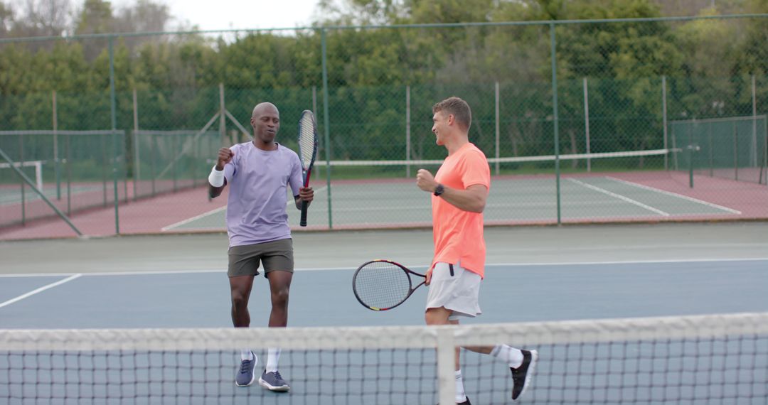 Two men celebrating tennis game on court - Free Images, Stock Photos and Pictures on Pikwizard.com