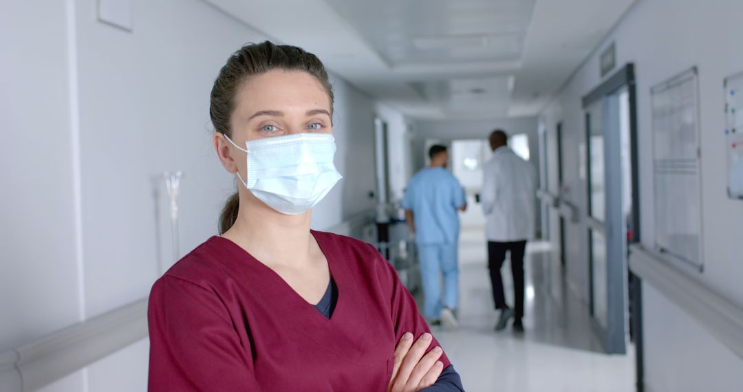 Female Nurse with Face Mask Standing in Hospital Hallway - Free Images, Stock Photos and Pictures on Pikwizard.com