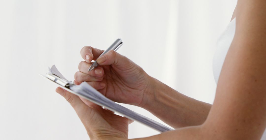 Close-up of woman holding pen and writing on paper - Free Images, Stock Photos and Pictures on Pikwizard.com