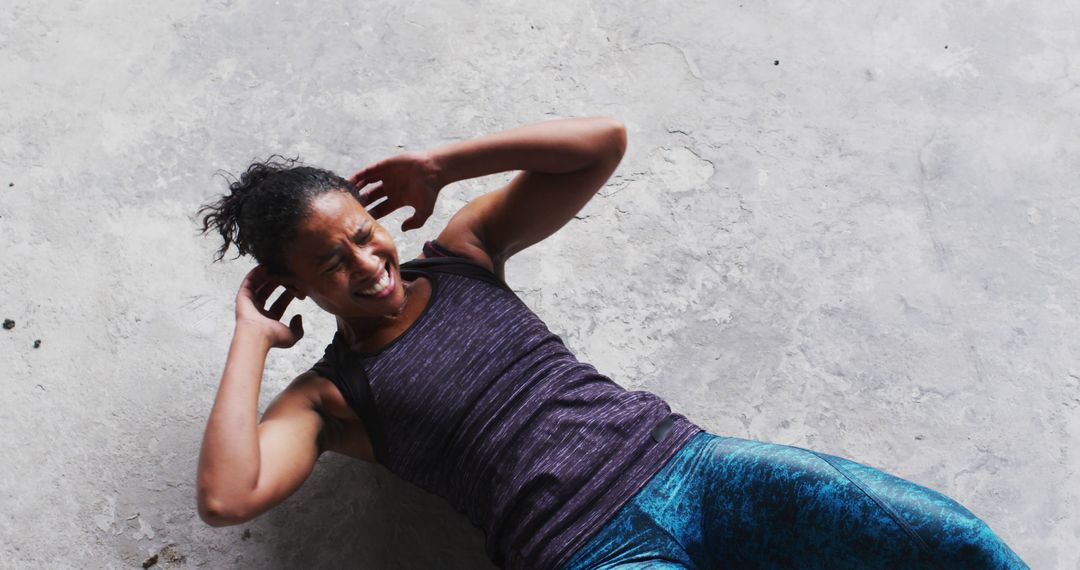 Young Woman Doing Sit-Ups on Concrete Floor in Athletic Wear - Free Images, Stock Photos and Pictures on Pikwizard.com