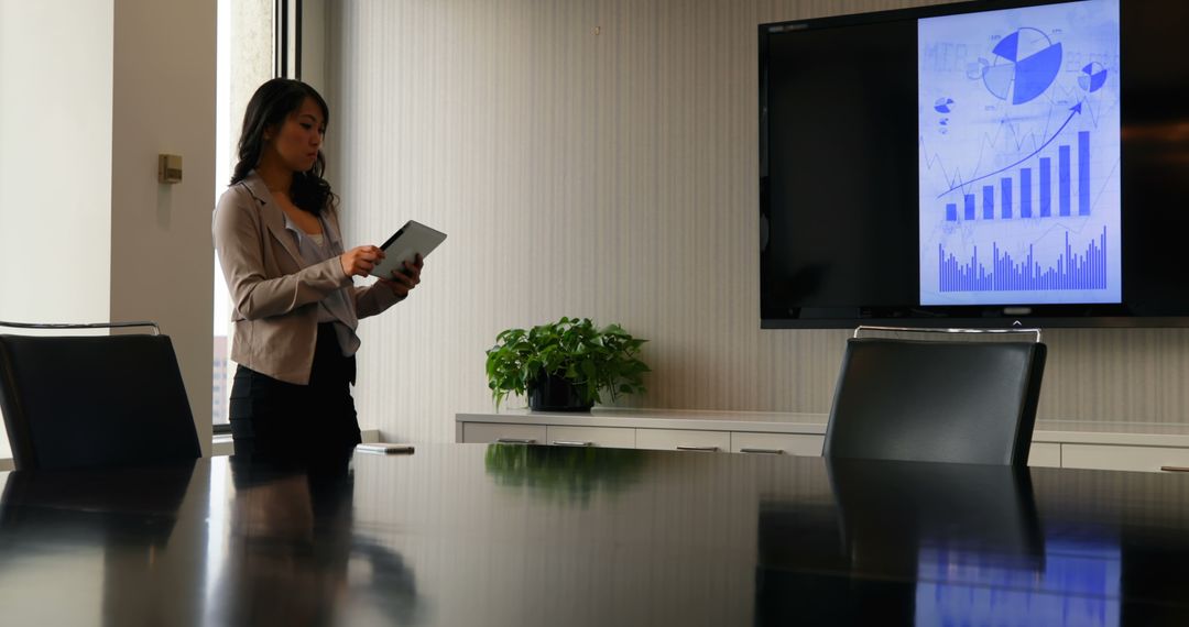 Businesswoman Analyzing Digital Tablet in Modern Conference Room - Free Images, Stock Photos and Pictures on Pikwizard.com